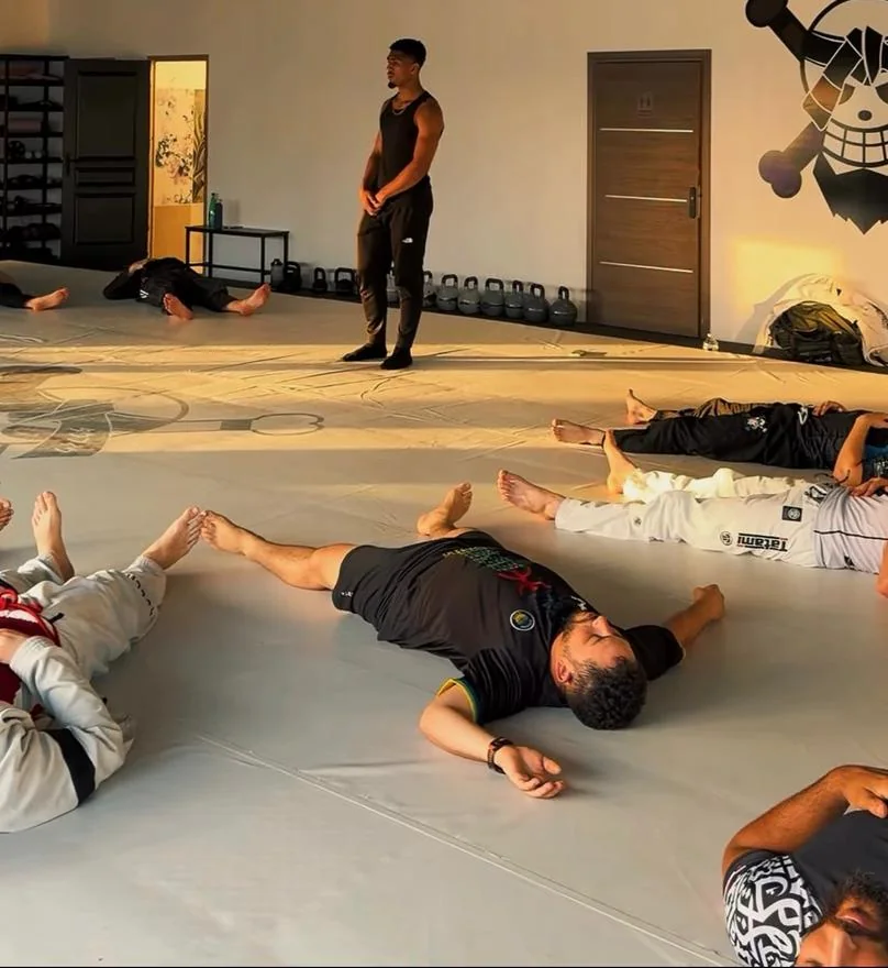 Séance de sophrologie collective au sol, dans une académie de sports de combat